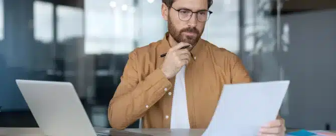 business owner reviewing pros and cons of SBA loans for financing a business acquisition with financial documents and calculator