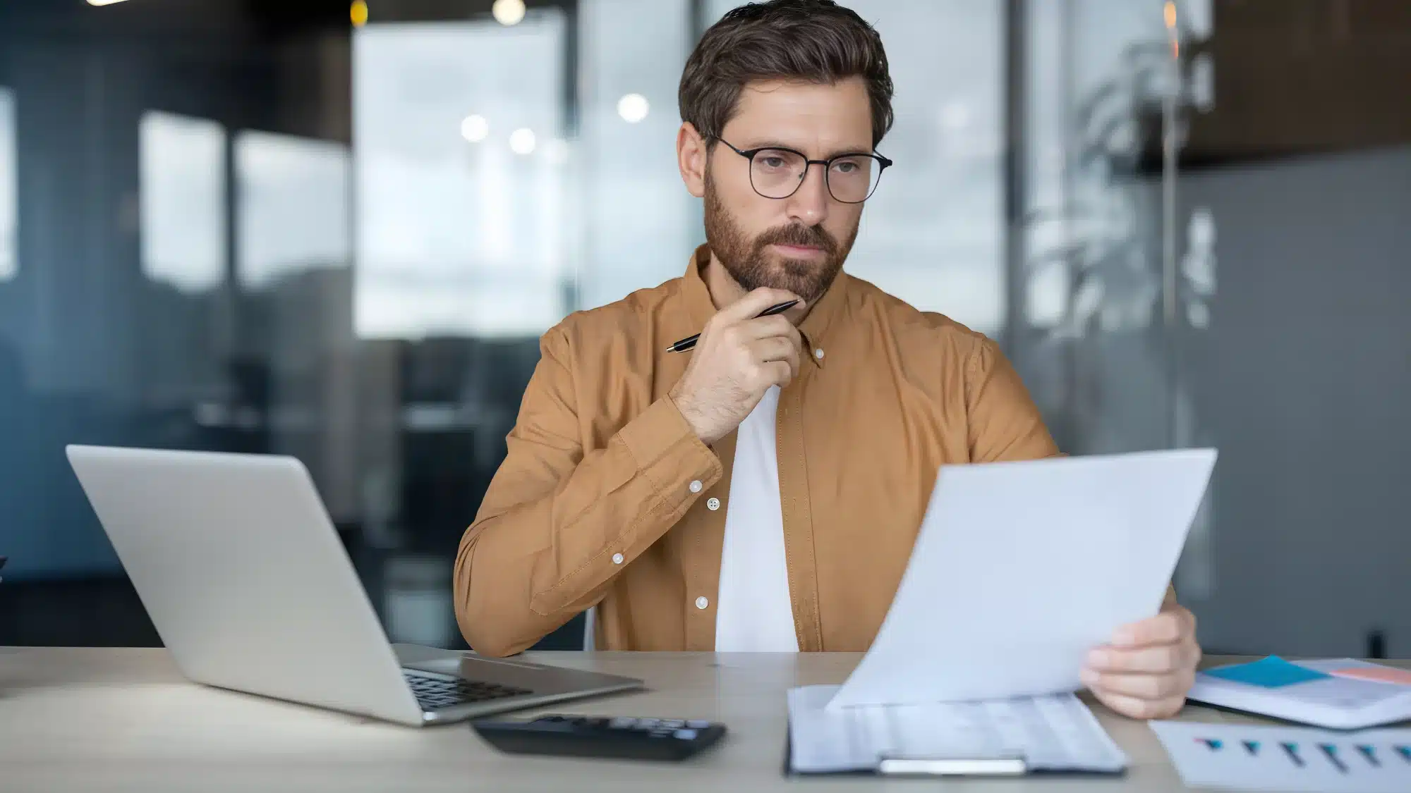 pros-and-cons-of-using-sba-loans-as-the-best-option-for-business-acquisitions business owner reviewing pros and cons of SBA loans for financing a business acquisition with financial documents and calculator